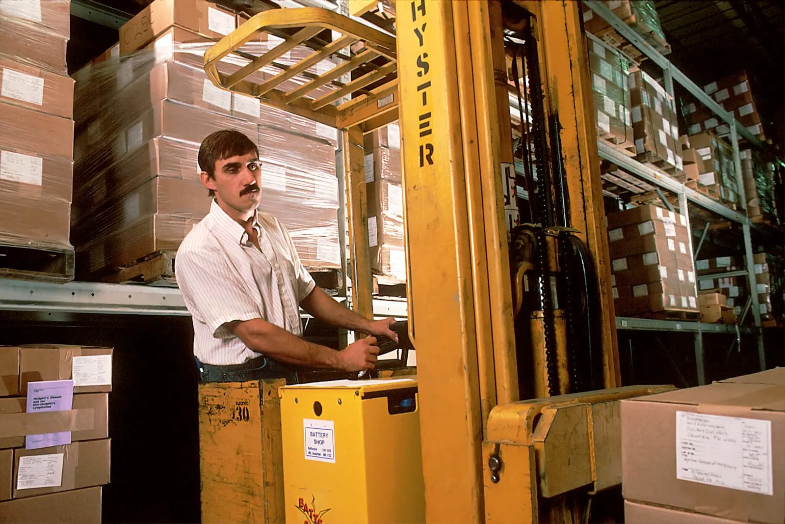 A forklift operator moving cartons in a warehouse